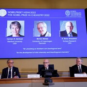 Jonas Aqvist, président du comité Nobel de chimie, Hans Ellegren, secrétaire général de l'Académie royale des sciences de Suède et Olof Ramstrom, membre du comité Nobel de chimie annoncent les lauréats du prix Nobel de chimie 2022 : Carolyn R. Bertozzi, Morten Meldal et Barry Sharpless, lors d'une conférence de presse à l'Académie royale des sciences de Suède à Stockholm, le 5 octobre 2022. 