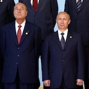 Les présidents Jacques Chirac, Vladimir Poutine et George W. Bush debout regardant le ciel.