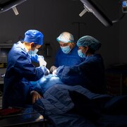 Une équipe médicale procède à une chirurgie.