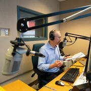 Christian Riou dans le studio de radio d'ICI Manitoba.