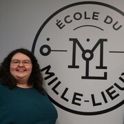 Deux femmes devant un mur avec un logo de l'école du Mille-Lieux.