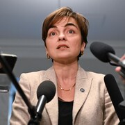 La ministre québécoise de l'Immigration, Christine Fréchette, devant de nombreux micros. 