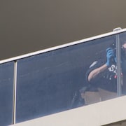Une policière prends des photos du balcon en question.