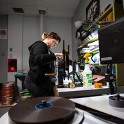 Eva Létourneau observe une pellicule de film dans un bureau.