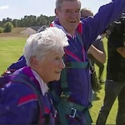 Clare Nowland marche à côté de son instructeur, entourée de caméras.