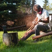Un homme travaille du bois dans un jardin.