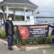 Deux femmes tiennent une affiche  indiquant « Abitibi-Témiscamingue. Travailler à se rendre malade, c'est terminé. 131 000 raisons d'unir nos forces ».