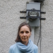 Francine Lajoie devant un compteur d'électricité.
