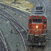 Une locomotive du CN circule sur des rails par temps pluvieux.