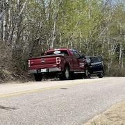 Accident entre une camionnette rouge et une voiture noire en position face à face.