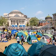 Des dizaines de tentes et des centaines de personnes sur le campus de Columbia, un jour ensoleillé.
