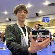 Un élève présente son robot qui combattra à la Polytechnique de la Saskatchewan, le 2 mai 2024.