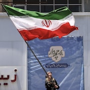 Une femme iranienne brandit le drapeau national à Téhéran, le 15 juin 2026.