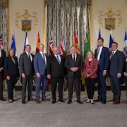 Les premiers ministres prennent la pose devant une série de drapeaux.