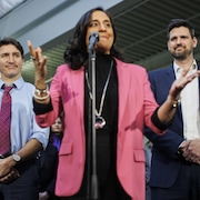 Justin Trudeau et Sean Fraser entourent Anita Anand lors d'un point de presse.