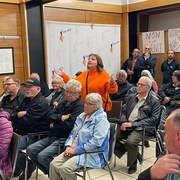 Une femme est debout pour s'adresser aux élus de Val-d'Or. Des dizaines de citoyens l'écoutent.