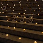 Le chiffre 259 sur les marches du palais législatif entouré de bougies et d'images de ballons noirs.