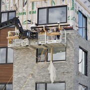 Deux ouvriers du bâtiment construisent un immeuble. 