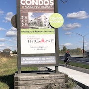 une affiche qui annonce la construction d'un complexe de 1400 condos.