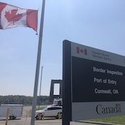 Un panneau du poste de contrôle frontalier de Cornwall et un drapeau canadien.