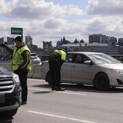 Un policier de la Sûreté du Québec qui intercepte les automobilistes.