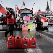 Un homme avec un chandail et un drapeau du Canada pendant le convoi.