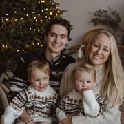 Une famille devant un arbre de Noël