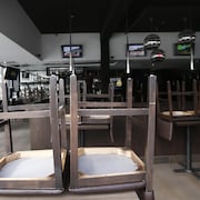 Des chaises sur des tables dans un restaurant fermé.