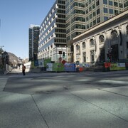 Une seule personne marche sur la rue Sainte-Catherine au centre-ville de Montréal en pleine journée.