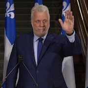 Philippe Couillard saluant de la main.