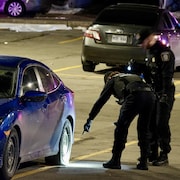 Des policiers du SPVM examinent un véhicule.                