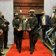 La Coupe Memorial arrive à St-Jean. Des policiers transportent la Coupe, devant une foule de gens.