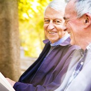 Deux hommes âgés assis sur un banc de parc.