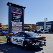 Des voitures de police à proximité d'un bâtiment commercial.