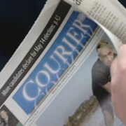 Une personne lit le journal. 