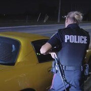 Un contrôle de police devant une voiture.