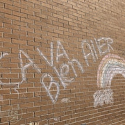Un arc-en-ciel Ça va bien aller sur un mur d'école.