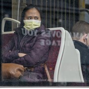 Une femme porte un masque assise dans un tramway.