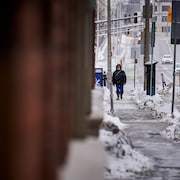 Un homme marche dans la rue en hiver. 