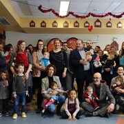 Des mères et leurs bébés, ainsi que le député Harold LeBel et le maire de Rimouski, Marc Parent, sont regroupés pour une photo de groupe.