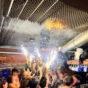 Des jeunes gens tiennent des bouteilles de champagne avec des bougies &eacute;tincelantes dans le bar Le Constellation de Crans-Montana, en Suisse. Le plafond en mousse s'embrase. 