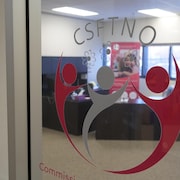 Un logo de la CSFTNO dans la porte qui donne sur ses bureaux. 