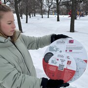Madame Sassandra Bergounioux, tient dans ses mains un exemple des pancartes qui seront installées au parc Provencher.
