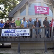 Des membres du syndicat devant le quartier général de grève avec des banderôles.