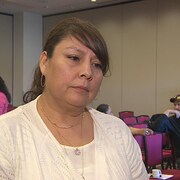 Une femme autochtone debout dans une salle de réunion pendant une entrevue.