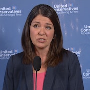 Danielle Smith répond aux questions des journalistes à un podium.