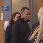 Un homme entre dans une salle de cour.