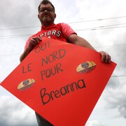 Un homme tenant une pancarte sur laquelle il est écrit : « Oui le Nord pour Breanna »