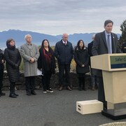 Le premier ministre David Eby debout devant un podium lors d'une conférence de presse à Vancouver.