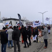 Des manifestants tiennent des banderoles.